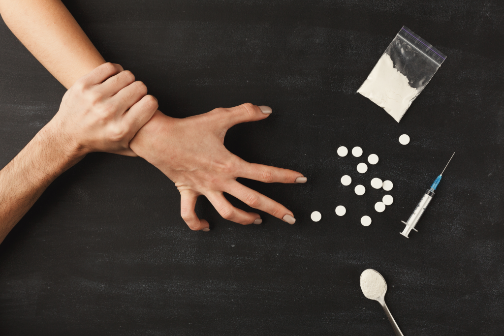 guy holding female's hand away from drugs